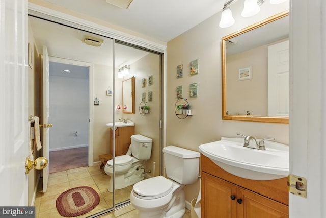 bathroom featuring baseboards, toilet, vanity, and tile patterned flooring