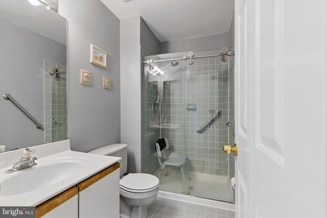 bathroom with a tile shower, tile patterned flooring, toilet, and vanity