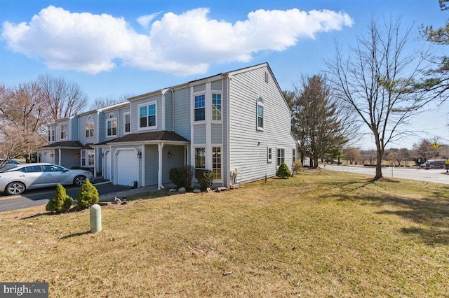 view of front of property featuring driveway, an attached garage, and a front yard