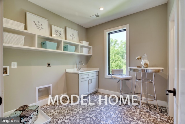 washroom with tile patterned flooring, hookup for an electric dryer, a sink, visible vents, and baseboards