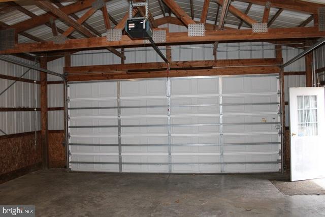 garage with metal wall and a garage door opener