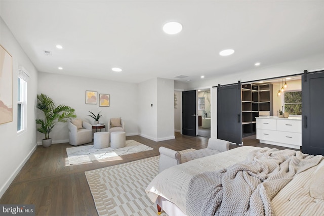 bedroom featuring dark wood-style floors, a barn door, baseboards, and recessed lighting