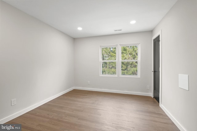 spare room with recessed lighting, visible vents, baseboards, and wood finished floors