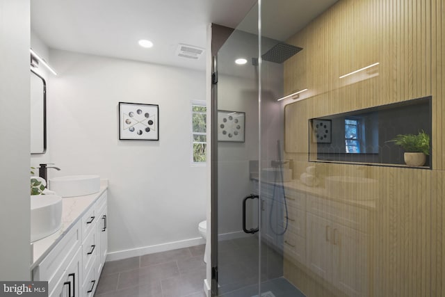 bathroom featuring toilet, a sink, visible vents, double vanity, and a stall shower