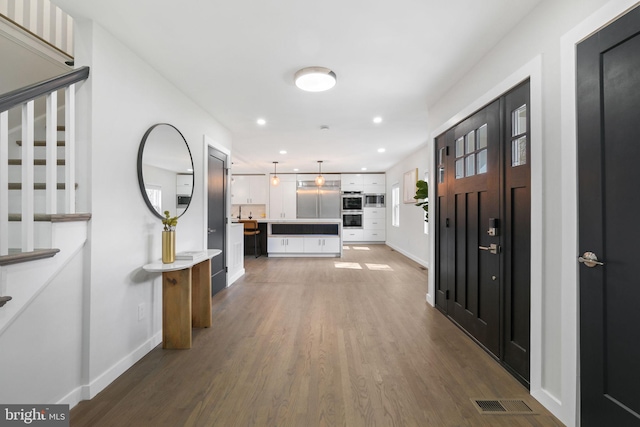 foyer featuring baseboards, stairway, dark wood-type flooring, and recessed lighting