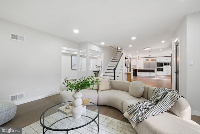 living room featuring light wood-style floors, stairs, visible vents, and recessed lighting