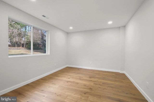 spare room with baseboards, visible vents, wood finished floors, and recessed lighting