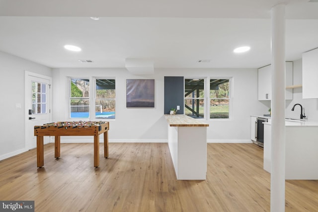 playroom with recessed lighting, visible vents, light wood-style flooring, a sink, and baseboards