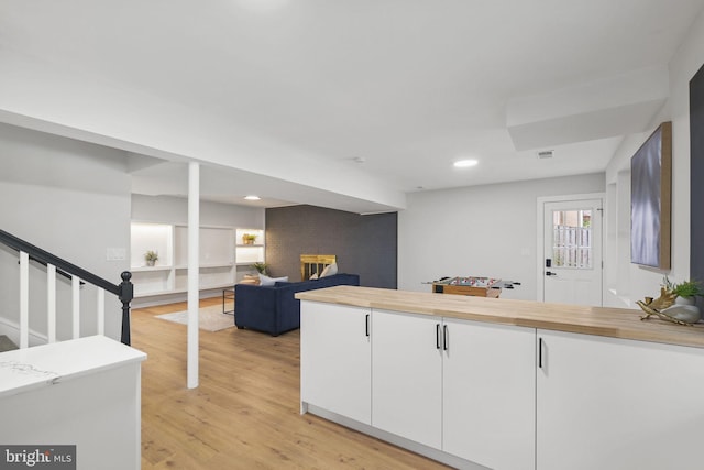 kitchen with visible vents, white cabinets, light wood-style flooring, a fireplace, and recessed lighting