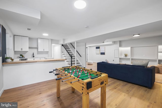 playroom featuring visible vents, a sink, and light wood finished floors