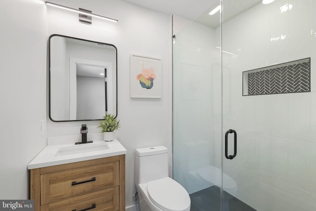 full bath with vanity, a shower stall, and toilet