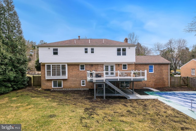 back of house featuring a deck, a fenced backyard, brick siding, stairway, and a lawn