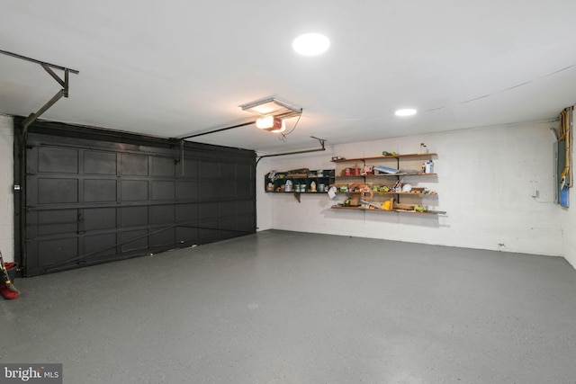 garage featuring concrete block wall and a garage door opener