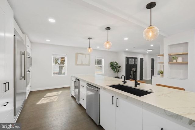 kitchen featuring dark wood-style flooring, a sink, white cabinets, stainless steel dishwasher, and light stone countertops