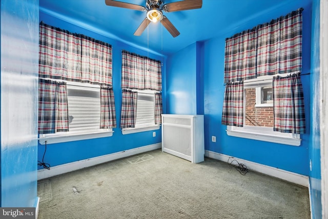 spare room featuring carpet, a ceiling fan, and baseboards