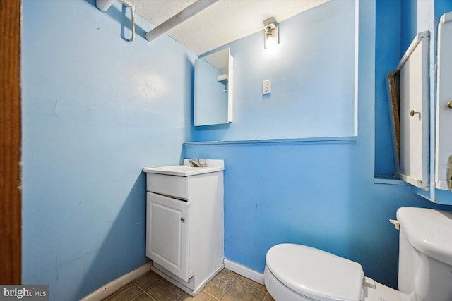 bathroom with tile patterned floors, vanity, toilet, and baseboards