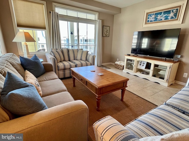 living area with baseboards and tile patterned floors