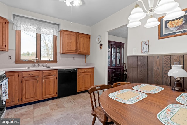 kitchen with brown cabinets, black dishwasher, light countertops, and a sink