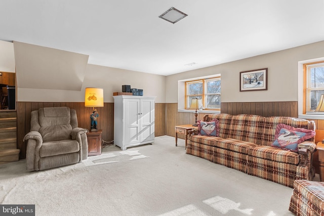 living area featuring wainscoting, wooden walls, and carpet flooring