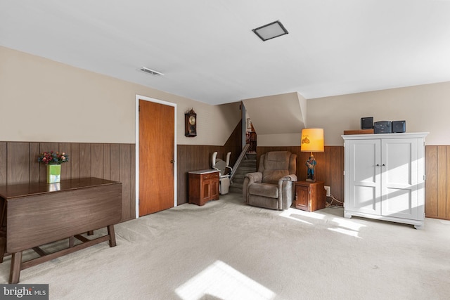 sitting room with carpet, a wainscoted wall, and wooden walls