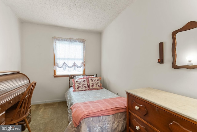 bedroom featuring carpet, baseboards, and a textured ceiling