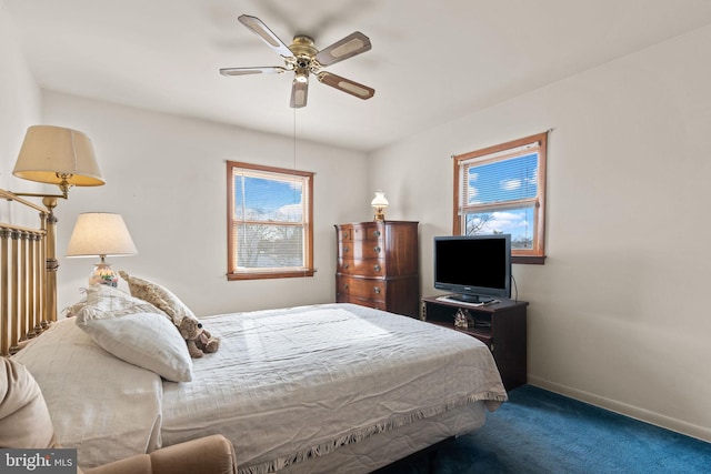 carpeted bedroom with a ceiling fan, multiple windows, and baseboards