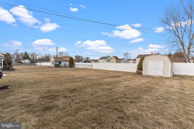 view of yard with a storage shed, an outbuilding, and a fenced backyard