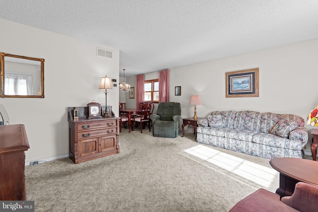 living area with an inviting chandelier, a textured ceiling, visible vents, and carpet flooring