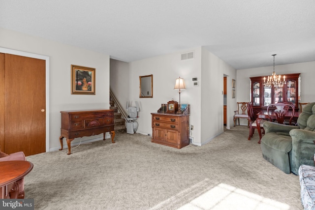 living area with a chandelier, a textured ceiling, visible vents, stairway, and carpet