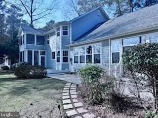 rear view of house featuring a lawn