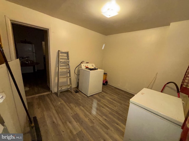 washroom featuring washer / clothes dryer, dark wood finished floors, and laundry area