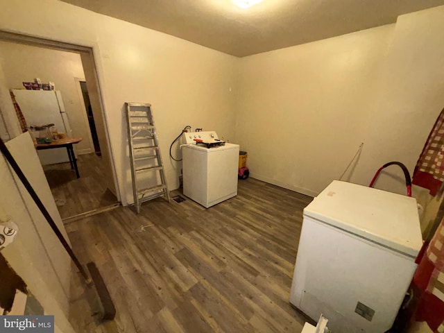 clothes washing area featuring dark wood-style floors, washer / clothes dryer, and laundry area