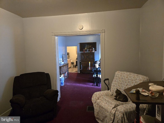 living area featuring carpet floors and visible vents