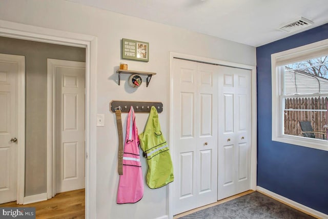 interior space featuring wood finished floors, visible vents, and baseboards