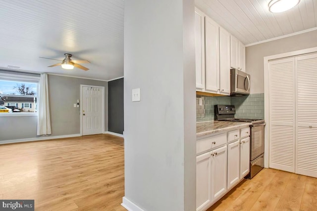 kitchen featuring tasteful backsplash, stove, stainless steel microwave, ornamental molding, and light countertops