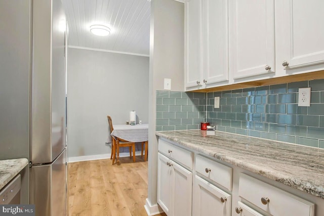 kitchen with crown molding, tasteful backsplash, appliances with stainless steel finishes, white cabinetry, and light wood-type flooring