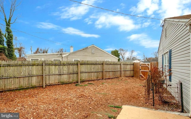 view of yard featuring a fenced backyard and a gate