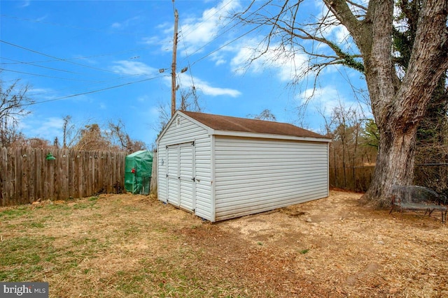 view of shed featuring fence