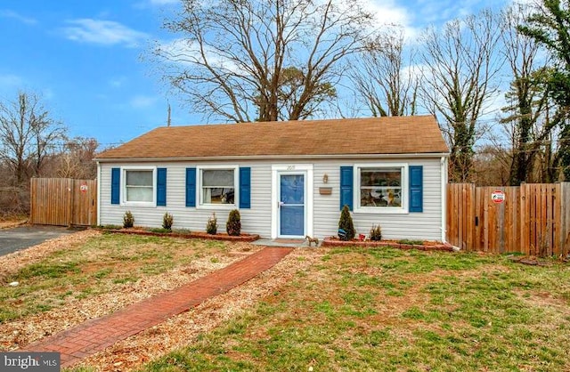 view of front facade featuring fence and a front lawn