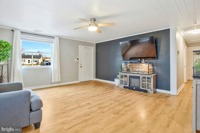 living room with baseboards, a ceiling fan, crown molding, and wood finished floors