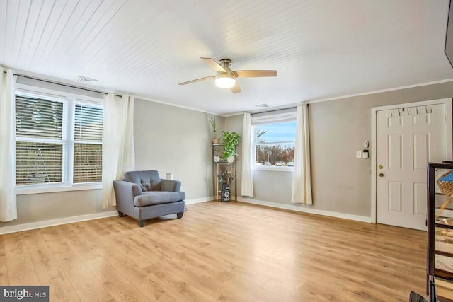 sitting room featuring light wood finished floors, ceiling fan, baseboards, and crown molding