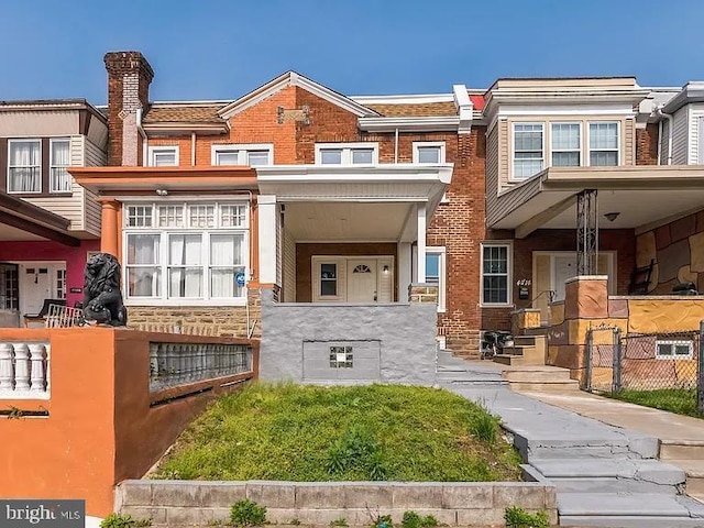 view of front of home with brick siding and fence