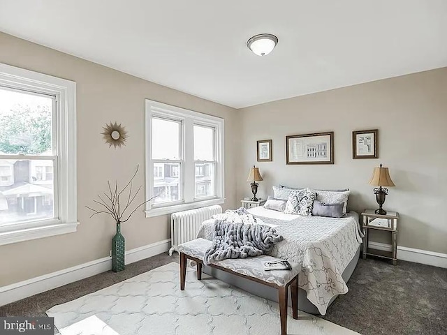 bedroom featuring radiator, dark carpet, and baseboards