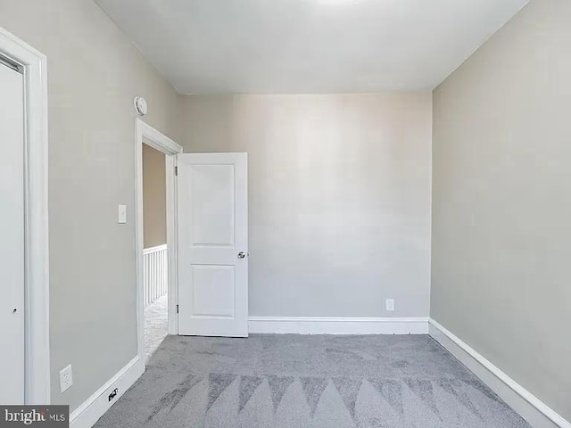 spare room featuring carpet and baseboards