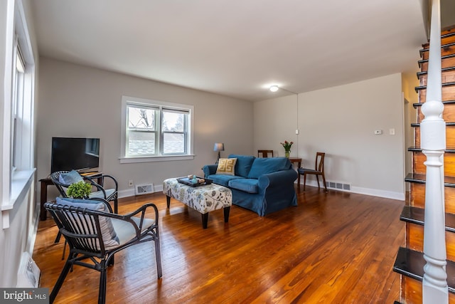 living area featuring wood finished floors, visible vents, and baseboards