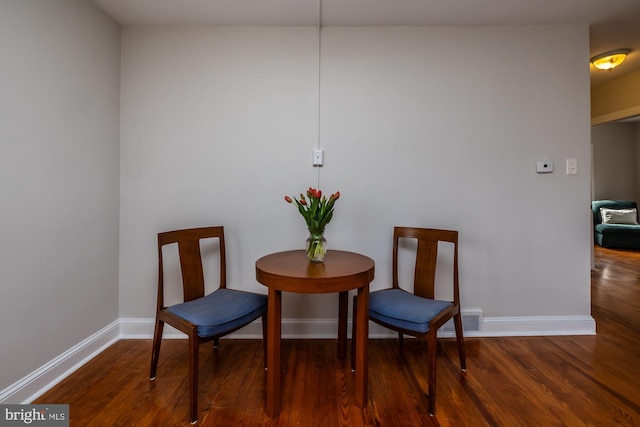 living area featuring wood finished floors, visible vents, and baseboards