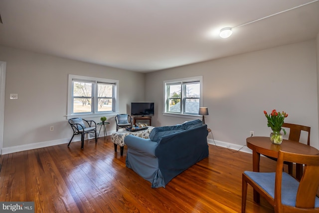 living area featuring baseboards and hardwood / wood-style floors