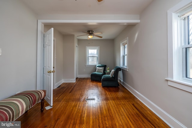 living area with wood-type flooring, baseboards, and ceiling fan