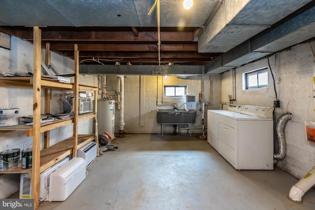 basement featuring water heater, a sink, and washing machine and clothes dryer