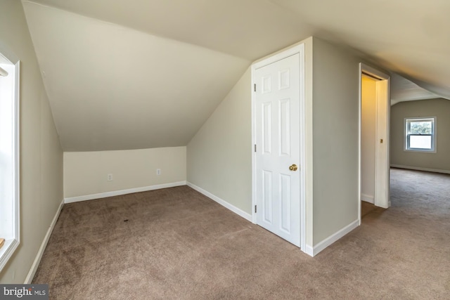 additional living space with carpet, vaulted ceiling, and baseboards